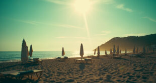 Empty beach chairs and closed umbrellas scattered across a deserted Croatian beach at sunrise with azure waters