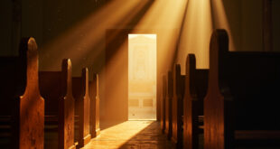 Empty wooden pews and altar in a dimly lit church sanctuary with light streaming through open doors
