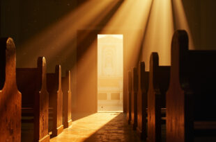 Empty wooden pews and altar in a dimly lit church sanctuary with light streaming through open doors