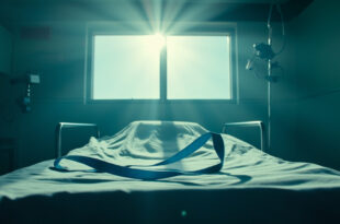 Empty hospital recovery room with blue medical sling on bed, surrounded by rehabilitation equipment in sterile lighting