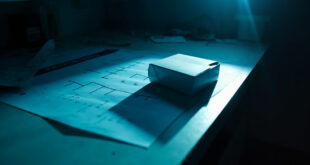 Unopened DNA test kit sitting beside blank family tree chart on laboratory desk with scientific equipment