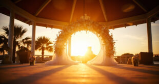 Empty decorated wedding altar with flower arch at sunset in a waterfront park pavilion