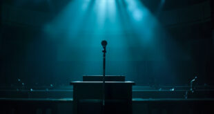 Empty parliamentary chamber at night after debate, with lone microphone on podium illuminated in blue and silver light
