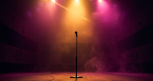Empty concert stage with lone microphone stand illuminated by golden spotlight against deep purple background in abandoned hall