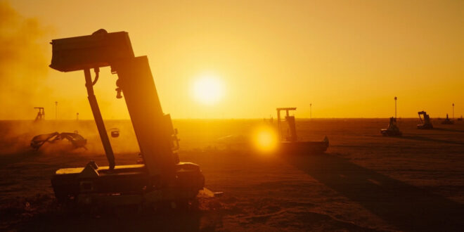 Abandoned military base with grounded aircraft and unused missile defense systems at desert compound during dusk after strike