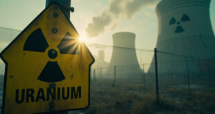 Abandoned nuclear facility at dawn with prominent radiation warning signs and empty cooling towers silhouetted against early light