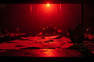 Abandoned military command center at night showing empty beds with military insignia and classified documents on desk