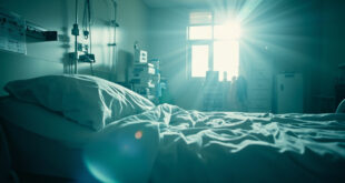 Empty hospital room at dawn with unmanned medical equipment and vacant bed with charts, bathed in soft blue light.