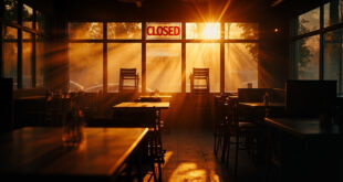 Empty restaurant interior with stacked chairs, closed sign, and darkened windows showing aftermath of business closure