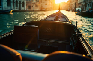 Empty ornate water taxi drifts through deserted Venetian canals at morning, bathed in gold and blue light