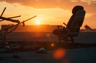 Lone undamaged airplane seat surrounded by aircraft debris on abandoned runway at dusk, illuminated by orange flames