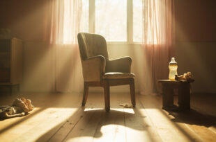 Empty rocking chair with scattered baby items in peaceful nursery room, abandoned baby bottle on wooden table