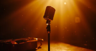 Vintage microphone and guitar stand alone in an empty recording studio, bathed in amber and burgundy light