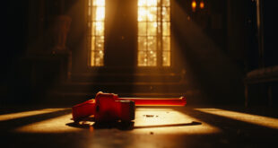 Fluorescent orange sledgehammer abandoned on marble tiles in luxury villa courtyard at dawn, casting long shadows