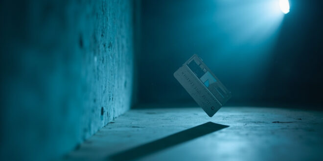 Navy blue credit card suspended mid-air against plain wall in empty home interior, part of viral social media challenge