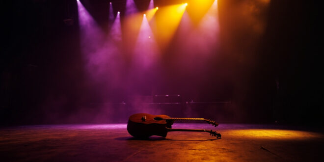 Abandoned acoustic guitar sits alone on dimly lit concert stage, bathed in golden spotlight against deep purple backdrop