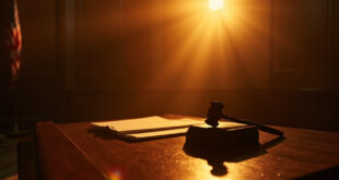 Empty federal courtroom with legal documents on judge's bench and wooden gavel on sound block, awaiting verdict