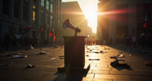Abandoned protest banners and an empty megaphone on a podium in a deserted city square after a political rally