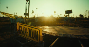 Cordoned off dangerous trampoline with warning signs at an abandoned fairground at dawn, yellow barriers visible