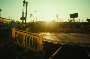 Cordoned off dangerous trampoline with warning signs at an abandoned fairground at dawn, yellow barriers visible