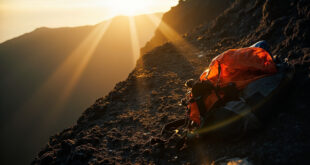 Empty mountain trail with abandoned hiking equipment at cliff edge in desolate Mount Rinjani volcanic crater landscape