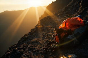 Empty mountain trail with abandoned hiking equipment at cliff edge in desolate Mount Rinjani volcanic crater landscape