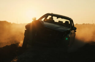 Overturned BMW wreckage lies damaged in an empty rural field at dawn, highlighting aftermath of traffic accident