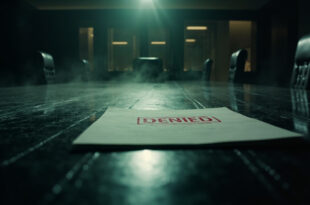 Classified documents with red DENIED stamp on polished conference table in empty high-security briefing room at night