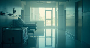 Empty hospital room with monitoring equipment and abandoned medical chart at dawn, documenting the aftermath of a cancer battle.