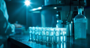Laboratory equipment and water sample tubes for polio virus testing arranged on bench in sterile blue-white laboratory at dawn