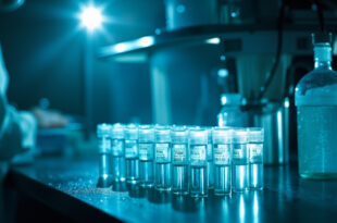 Laboratory equipment and water sample tubes for polio virus testing arranged on bench in sterile blue-white laboratory at dawn