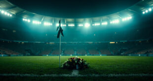 Memorial wreath and black ribbon on goalpost in empty football stadium at night during moment of remembrance