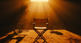 Empty director's chair and dust-covered vintage camera on abandoned film set in deserted Hollywood studio at dusk