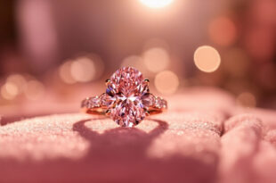 Luxury pink diamond engagement ring displayed on velvet cushion with rose gold accents in elegant jewelry setting