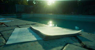 Empty swimming pool with floating legal documents in an abandoned backyard, with closed legal papers on a poolside table.