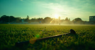 Abandoned polo equipment on empty Windsor grounds, featuring lone mallet on emerald grass under fading light