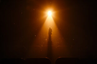 Empty spotlight illuminates a vacant stage in dimmed theater with empty seats, symbolizing an actor's absence