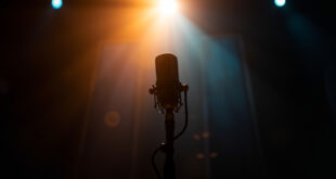 Empty microphone stand in a warmly lit recording studio, symbolizing awaited return to music as therapy