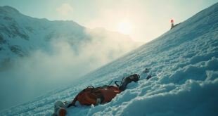Abandoned mountain rescue equipment with orange emergency beacon on snow-covered Swiss glacier at dawn