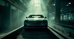 Unfinished Mercedes-Benz sedan sits abandoned on a motionless assembly line in an empty automotive factory