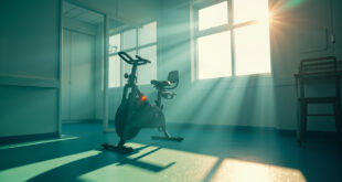 Specialized medical exercise bike sits unused in a sterile rehabilitation room, bathed in natural light