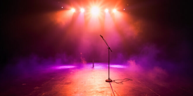 Abandoned concert stage with empty microphone stand illuminated by purple and gold spotlights in vacant venue after show