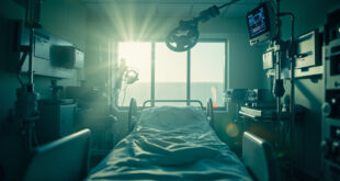 Empty hospital bed with life support equipment in a sterile corridor bathed in morning light