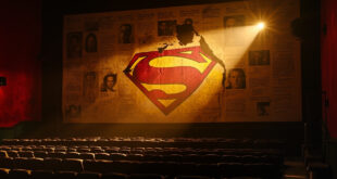 Torn Superman movie poster in dimly lit, deserted theater with empty screen displaying mixed critical reviews.