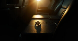 Diamond engagement ring with flight number engraving displayed on airplane tray table between two empty seats