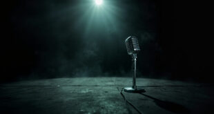 Abandoned vintage microphone stand illuminated by spotlight on empty dark concert stage, symbolizing rock music legacy