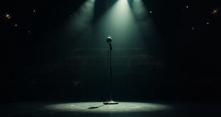 Empty microphone stand under spotlight on silent stage in darkened concert hall, symbolizing a heavy metal legend's death