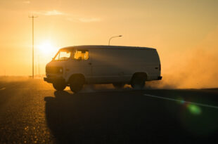 Abandoned white van on desolate Interstate 87 at dusk, bathed in amber light, suggesting a missing child emergency