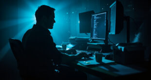Abandoned workstation with computer screens displaying code in a quiet office with programming tools and documentation