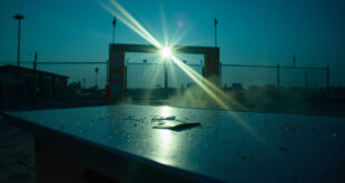 Closed border checkpoint at dawn with warning signs and an abandoned green card on inspection table
